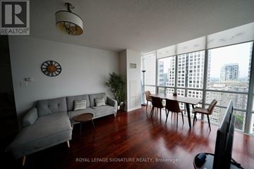 Mississauga (Fairview) condo for rent - A living room with a grey couch and a clock on the wall.