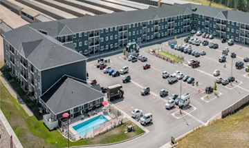 Rapid City apartment for rent - A large building with a parking lot in front of it.