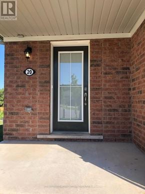 Brantford townhouse for rent - A door with a glass window and a black handle is on a brick wall.
