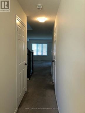 Brantford townhouse for rent - A hallway with a door on the left and a window on the right.