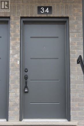 Guelph (Clairfields/Hanlon Business Park) townhouse for rent - A black door with a handle and a number 34 above it.