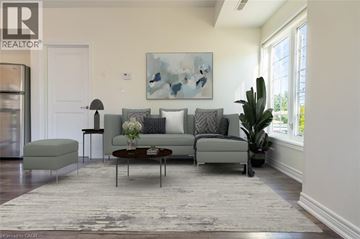 Milton condo for rent - A living room with a grey couch, a coffee table, and a painting on the wall.
