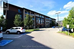 Guelph (Pineridge/Westminster Woods) condo for rent - A white car is parked in a parking lot in front of a building.