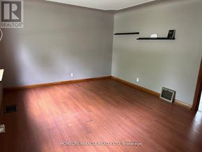 Waterloo apartment for rent - A room with wooden flooring and a wall-mounted shelf.