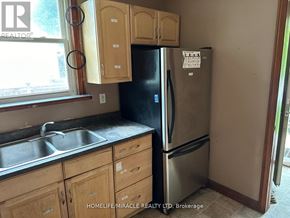 Waterloo apartment for rent - A kitchen with wooden cabinets and a black fridge.