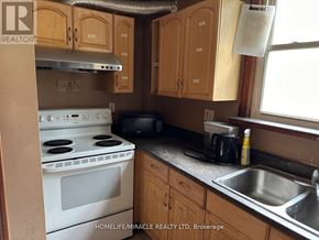 Waterloo apartment for rent - A kitchen with wooden cabinets and a white stove top oven.