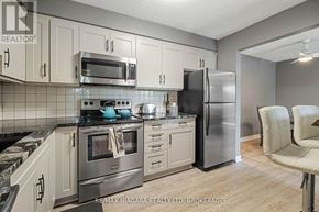 Thorold (Thorold Downtown) condo for rent - A kitchen with a stove top oven, microwave, and refrigerator.