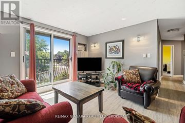 Thorold (Thorold Downtown) condo for rent - A living room with a red couch and a wooden coffee table.