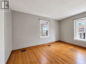 Toronto (Weston-Pellam Park) townhouse for rent - A room with wooden floors and two windows.