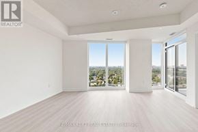 Toronto (Humber Heights) condo for rent - A spacious, empty room with a view of the cityscape outside the large windows.
