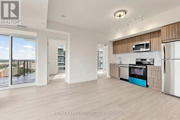 Toronto (Humber Heights) condo for rent - A spacious kitchen with wooden cabinets and a white refrigerator.
