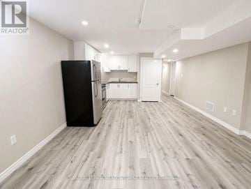 Milton (Be Beaty) apartment for rent - A spacious kitchen with a black refrigerator and wooden flooring.