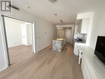 Toronto (Church-Yonge Corridor) condo for rent - A spacious living room with a television and a kitchen area in the background.