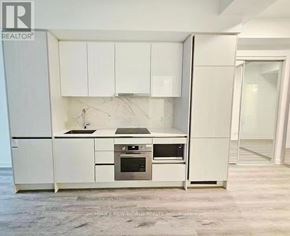 Toronto (Moss Park) condo for rent - A white kitchen with a refrigerator, oven, and microwave.