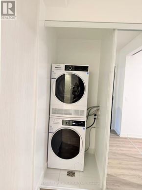 Toronto (Moss Park) condo for rent - A white washer and dryer stacked on top of each other in a small laundry room.