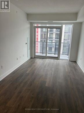 Mississauga (Mississauga Valleys) condo for rent - A room with wood flooring and a large window with a view of a building outside.