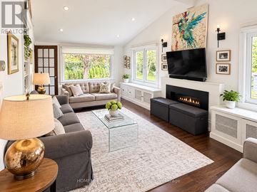 Toronto (Rosedale-Moore Park) apartment for rent - A living room with a grey couch, a glass coffee table, a fireplace, and a painting on the wall.