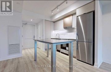 Toronto (Islington-City Centre West) condo for rent - A kitchen with a stainless steel refrigerator and a table with a blue metal frame.