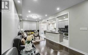 Brampton (Credit Valley) apartment for rent - A brokerage office with a black leather couch and a glass table with flowers on it.