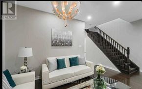 Brampton (Credit Valley) apartment for rent - A living room with a white couch, a chandelier, and a staircase.