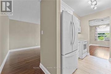 Lincoln (Beamsville) condo for rent - A white refrigerator in a kitchen with wood flooring.