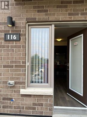 Pickering (Town Centre) townhouse for rent - A brown door with a glass window is on a brick wall with a sign that says 116.