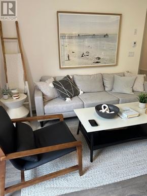 Pickering (Town Centre) townhouse for rent - A living room with a grey couch, a coffee table, and a painting on the wall.
