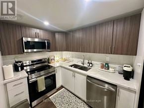 Milton (Co Coates) apartment for rent - A kitchen with a stove top oven, microwave, and sink.