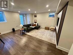 Milton (Co Coates) apartment for rent - A living room with a black couch and a rug.