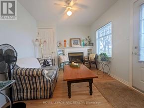 Fort Erie (Crystal Beach) apartment for rent - A living room with a striped couch, a coffee table, and a fireplace.