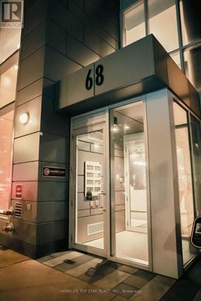 Toronto (Church-Yonge Corridor) condo for rent - A modern building entrance with a glass door and a sign that reads "68".