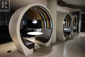 Toronto (Church-Yonge Corridor) condo for rent - A modern waiting area with circular chairs and a rainbow-colored wall.
