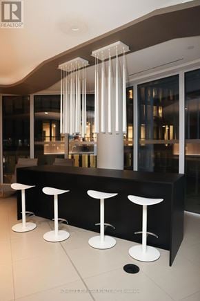 Toronto (Church-Yonge Corridor) condo for rent - A black bar with four white stools in front of a glass wall.