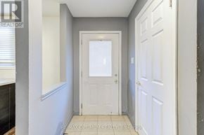 Brampton (Madoc) townhouse for rent - A hallway with a white door and a window with blinds.