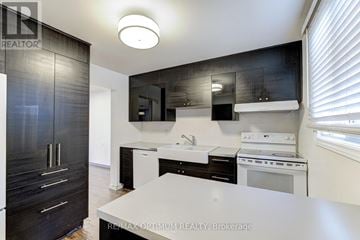 Brampton (Madoc) townhouse for rent - A modern kitchen with black cabinets and white appliances.