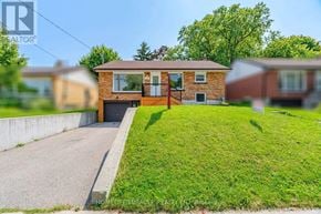 Waterloo apartment for rent - A house with a brown roof and a red gate is surrounded by a green lawn.