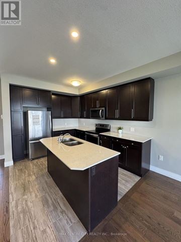 London North (North E) townhouse for rent - A kitchen with dark brown cabinets and a light counter top.