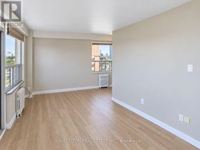 Toronto (Annex) condo for rent - A spacious room with wooden flooring and a window overlooking a cityscape.