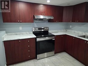 Brampton (Toronto Gore Rural Estate) apartment for rent - A kitchen with dark wood cabinets and stainless steel appliances.