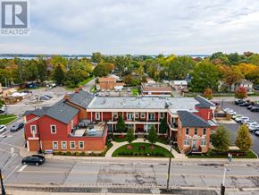 Niagara Falls (Chippawa) condo for rent - A large red building with a parking lot in front of it.