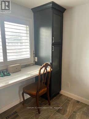 Toronto (Clairlea-Birchmount) apartment for rent - A black cabinet with a wooden chair in front of it.
