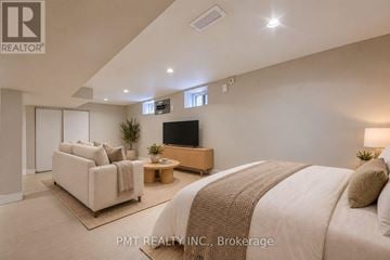 Toronto (High Park-Swansea) duplex for rent - A well-lit bedroom with a large bed and a flat-screen TV.