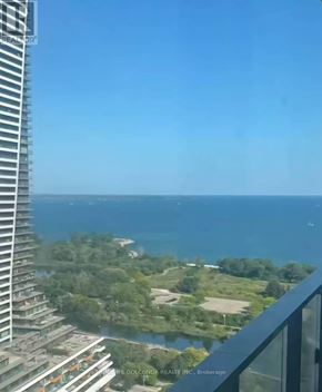 Toronto (Mimico) condo for rent - A view from a high-rise building overlooking a coastal landscape.