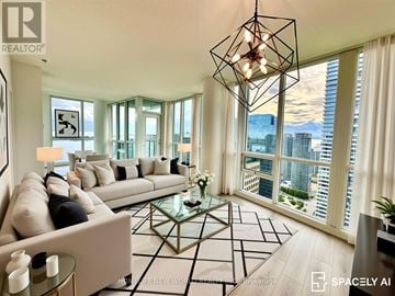 Toronto (Waterfront Communities) condo for rent - A modern living room with a large window overlooking the city.