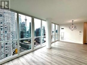 Toronto (Waterfront Communities) condo for rent - A spacious room with a view of the city skyline.