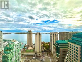 Toronto (Waterfront Communities) condo for rent - A cityscape with a large body of water in the background and a cloudy sky above.