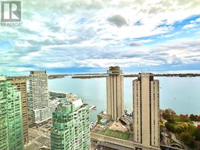 Toronto (Waterfront Communities) condo for rent - A cityscape with a large body of water in the background and a bridge crossing over it.