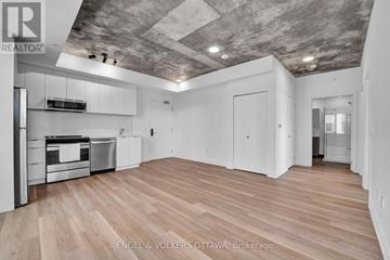 Ottawa apartment for rent - A spacious kitchen with wooden flooring and a ceiling with exposed beams.