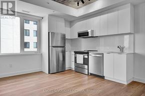 Ottawa apartment for rent - A modern kitchen with stainless steel appliances and white cabinets.