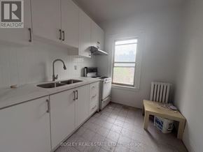 Toronto (Kensington-Chinatown) apartment for rent - A kitchen with white cabinets and a window.